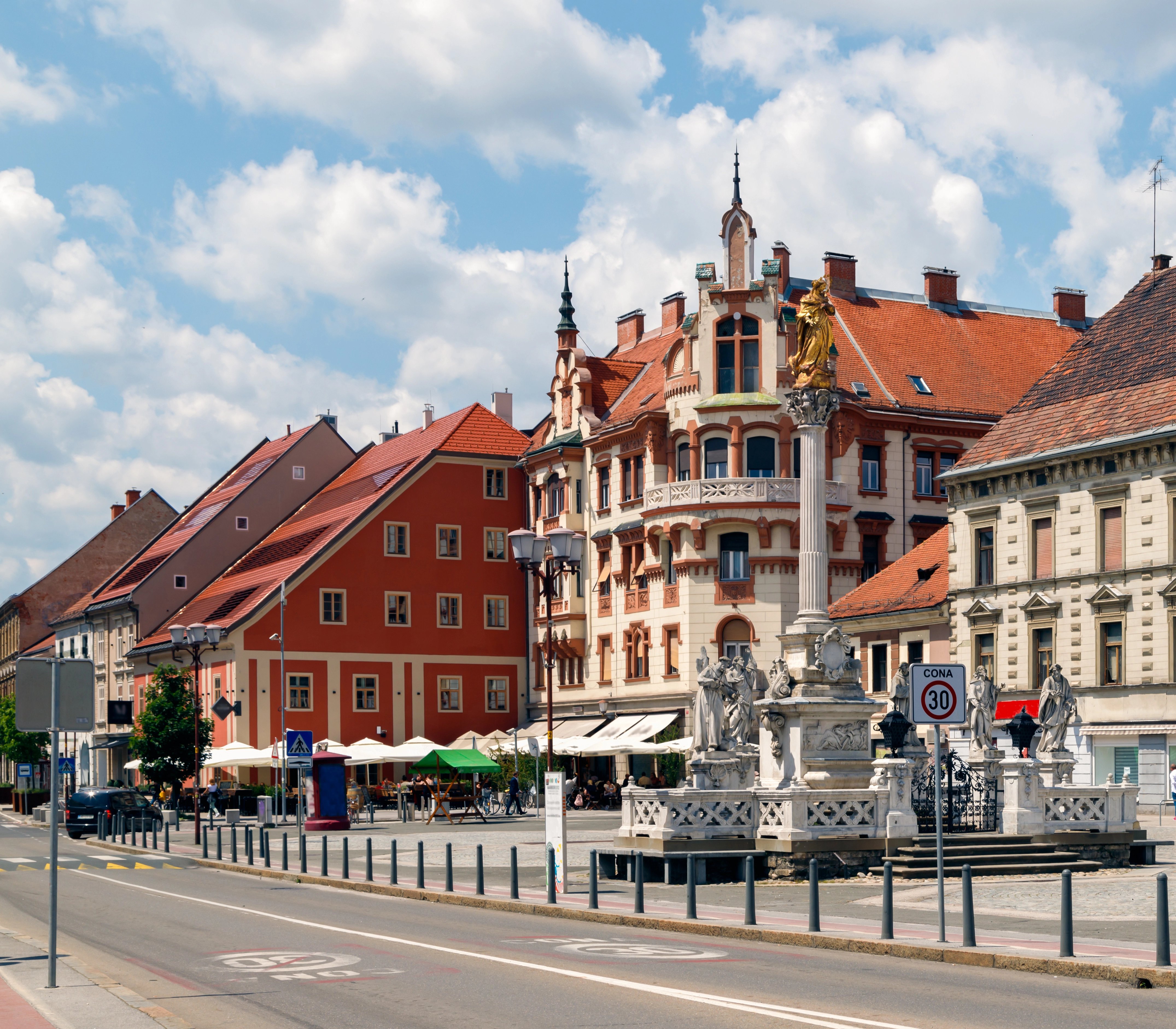 picture of a road, some houses and a fountain in Maribor