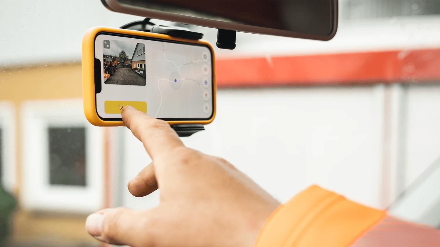 phone with the vialytics app in a windshield, with a person touching it with his finger