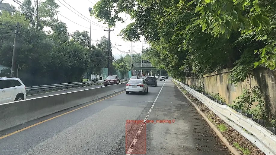 Street view of traffic with a highlighted area of damaged lane markings.
