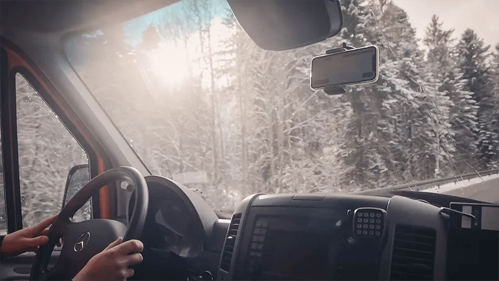 Driving through a snowy forest with the vialytics phone in the windshield