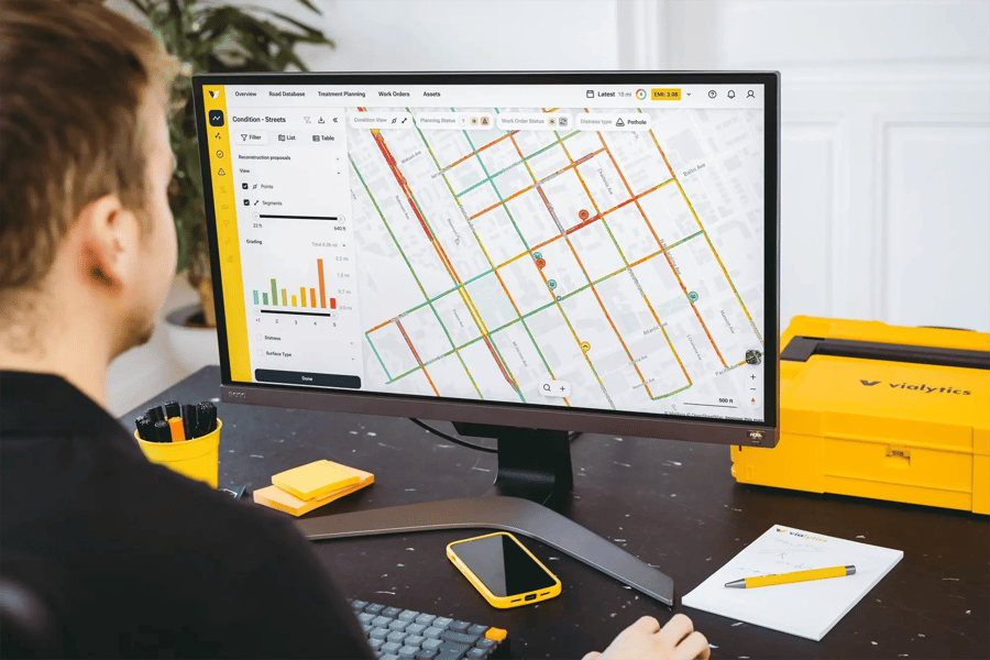 Employee at a desk reviewing a road network map in the vialytics web system