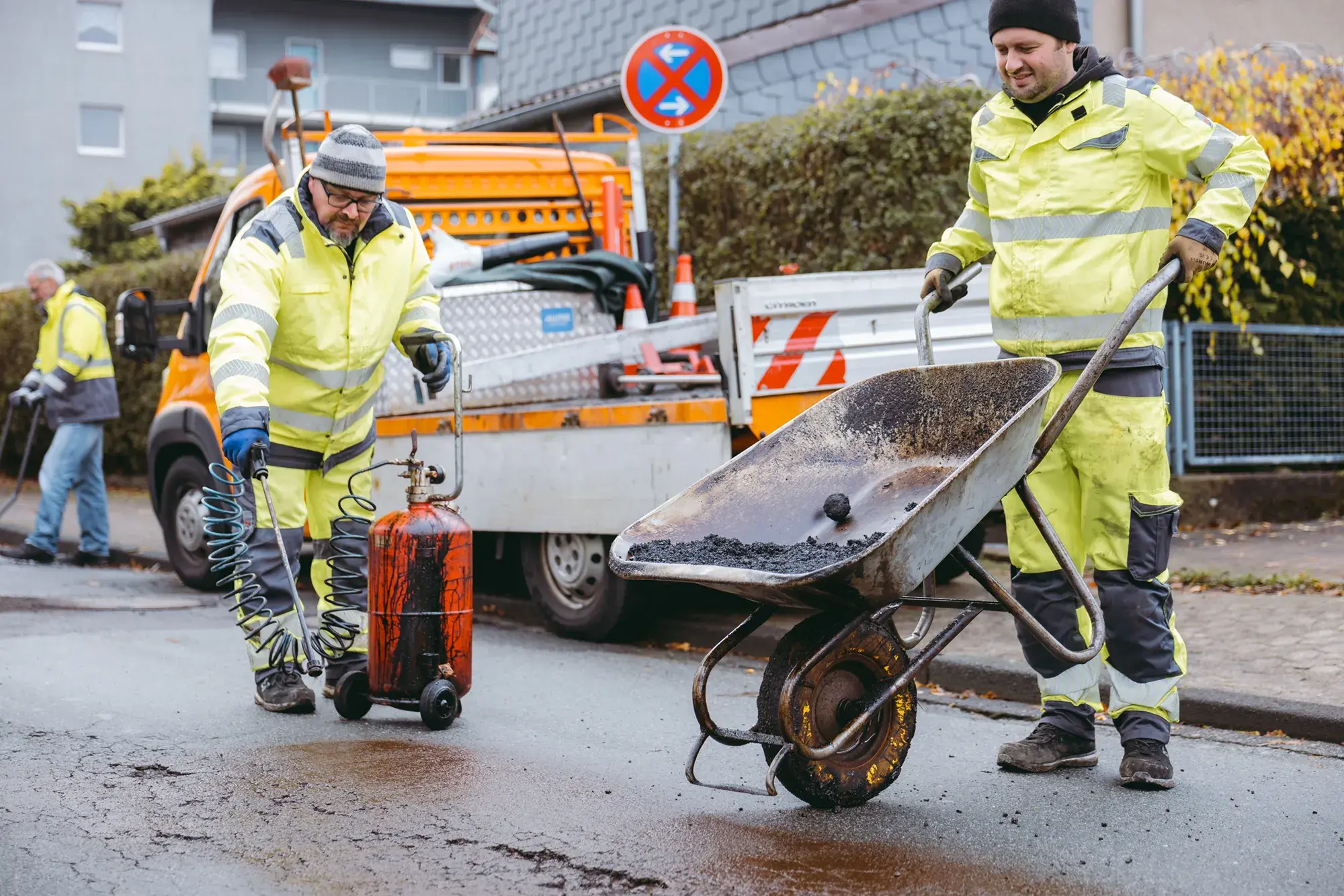 Construction workers repairing a pothole on a road
